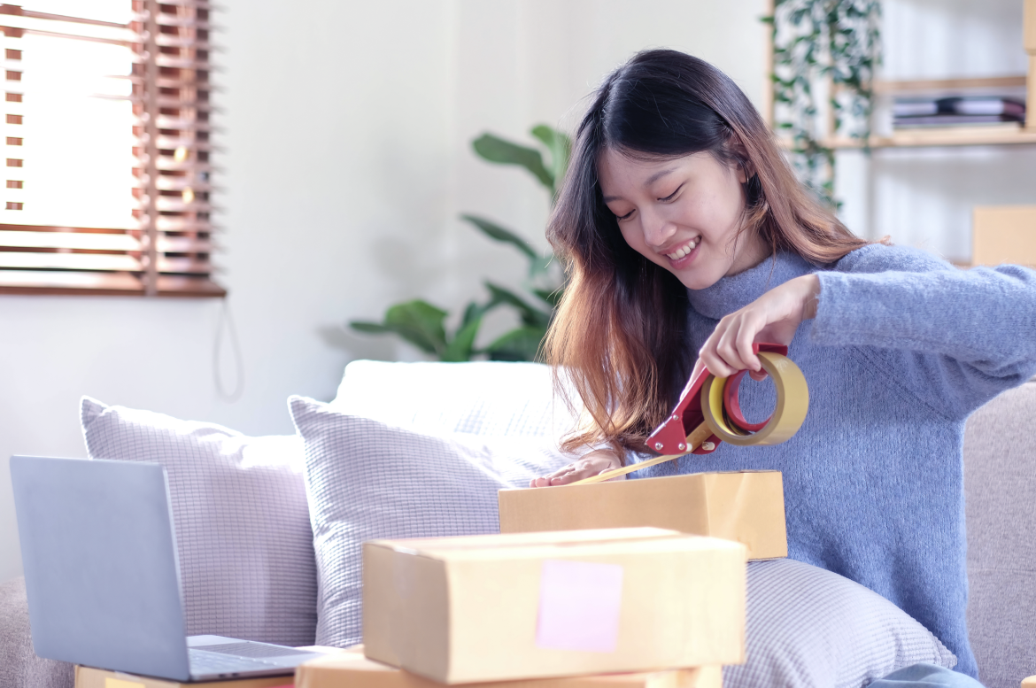Como calcular o preço certo do meu clube de assinatura? Imagem: mulher asiática embala pedido de clube de assinatura