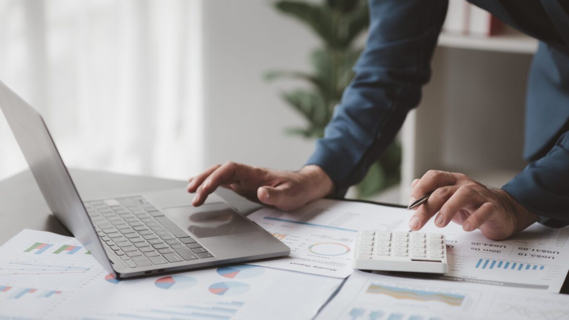 mão masculina digita em notebook em cima da mesa